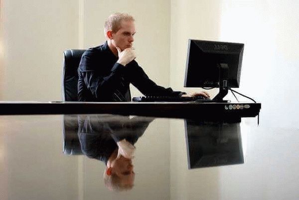 как узнать свой страховой стаж, мужчина сидит за столом и смотрит в монитор компьютера